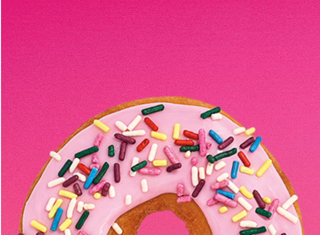 A glazed donut and a strawberry frosted donut with sprinkles